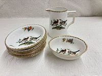 Group of stack of five plates, bowl and creamer showing overall quantity and pattern