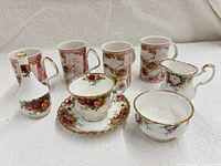 Group shot showing all mugs, teacup, saucer, creamer, sugar bowl, bud vase