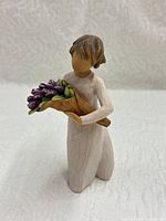 Front view of figurine holding tulip bouquet