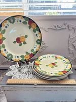 Platter on stand and stack of four dinner plates next to ruler