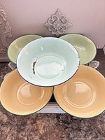 Top view of five pastel enamelware bowls showing colors and condition