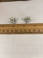 front view of earrings showing rhinestone arrangement with ruler for scale
