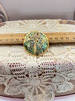 Front view showing abalone shell and Tree of Life motif with ruler for scale