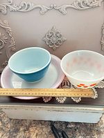 Group shot of both bowls stacked on two plates with ruler for scale