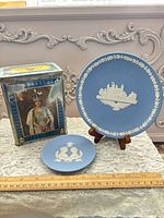 Group shot of two blue jasperware-style plates and royal portrait tin