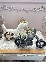 Both motorcycle figurines side by side with ruler for scale