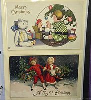 Two postcards: child with bear and toys, children in snow, in album