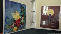 Open album showing two vintage Christmas cards: angel and candle designs