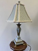 Full view of lamp unlit showing base, column, shade and cord