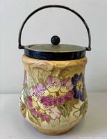 Front view of porcelain biscuit barrel showing floral decoration