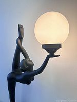 Close-up of figure’s upper body holding illuminated frosted globe