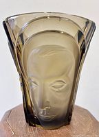 Front view of smoked glass vase showing face relief