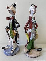 Front view of both ceramic clown figurines showing colours, poses and bases