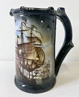 Side view showing sailing ship artwork and pierced rim