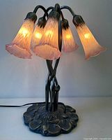 Lamp lit showing all five pink glass shades illuminated