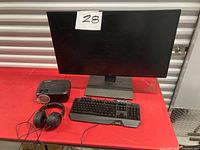 Front view of Acer monitor, ABOX projector, keyboard and headset