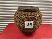 Full view of woven bamboo table on red surface