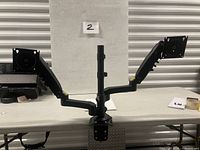 Front view of dual-arm monitor mount on table
