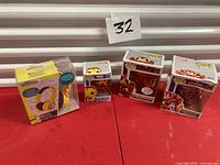 All four Funko Pop figures and Minions headphones on table