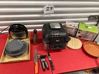Overview showing Ninja fryer, coffee maker, dishes, cutlery, boxed Starfrit gadgets