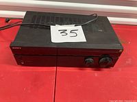 Front and top view of Sony STR-DH590 receiver on red surface