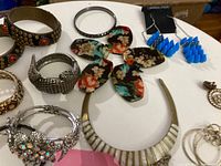 Assorted bracelets, earrings and bib necklace on table