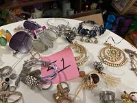 Tabletop view showing majority of assorted jewelry and sunglasses
