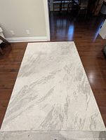 Full view of rug laying flat showing overall pattern and size against hardwood floor