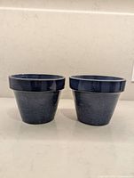 Front view of two blue glazed flower pots