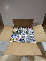 Open cardboard box filled with loose baseball cards