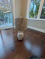 Lamp standing on floor, shade wrapped in plastic