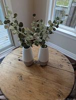 Both vases with faux plants on tabletop