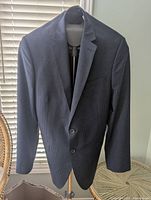 Front view of DKNY blazer hanging, showing notch lapel and two-button front