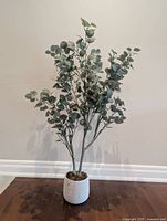 Full view of faux tree standing in white ceramic pot