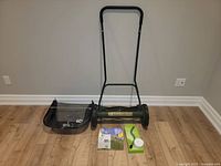 Full view of reel mower with grass catcher, sharpening kit components laid out