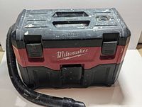 Front view of Milwaukee M18 vacuum with hose attached