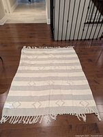 Full view of blanket laid flat showing stripes and fringe