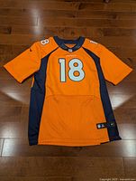 Front view of orange Denver Broncos #18 jersey