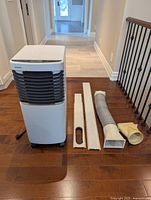 Portable air conditioner with all window kit components displayed
