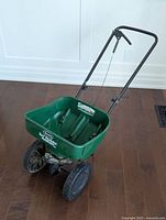 Front angled view of spreader showing hopper and wheels