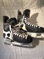 Side view of pair of CCM 557 Tacks hockey skates showing boot, laces, holders and blades