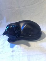 side view of black ceramic sleeping cat figurine