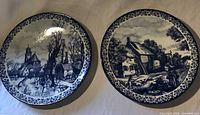 Two Delfts Chemkefa plates side by side showing seasonal scenes