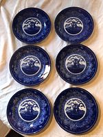 Six blue transferware plates displayed face up