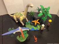 Overview of all components including Brachiosaurus, Pterodactyl on stand, explorers, cave, foliage, snake