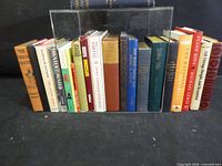 Entire row of approximately 20 books held between clear bookends