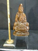 Full view of carved wood Guanyin statue beside ruler showing height