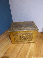 Front three-quarter view of gold-tone hammered metal trunk