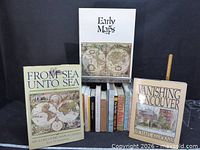 Group shot showing fourteen books with three titles facing outward and remaining spines visible