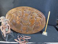 overall view showing wood plaque, terracotta figure, woven strap with measuring sticks for scale